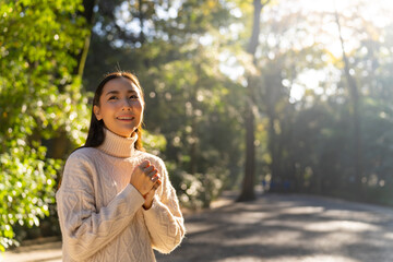 Happy Asian woman travel and looking beautiful nature in the park at traditional Meiji Jingu Shrine in Tokyo city, Japan. Attractive girl travel Japan landmark famous place in autumn holiday vacation.