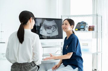Obstetrician explaining ultrasound pictures to a patient