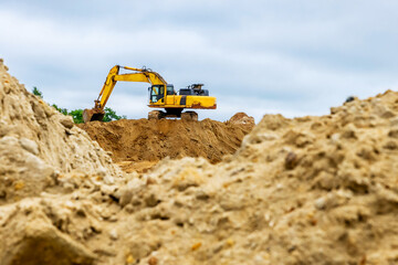 Obraz premium Excavator at the construction site. Concept of land works and site preparation for construction