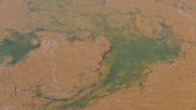 Muddy water flowing into clean bule aqua river Mekong at the start of south east Asia monsoon season.