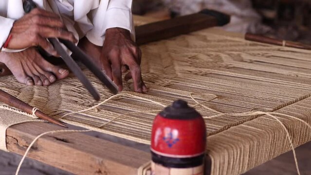 Artisan Checking Threading On A Charpai, A Traditional Woven Bed In Sindh, Pakistan