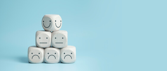 world mental health day concept or feedback rating and positive customer review, wood cube stacking with emotion face icon on blue background