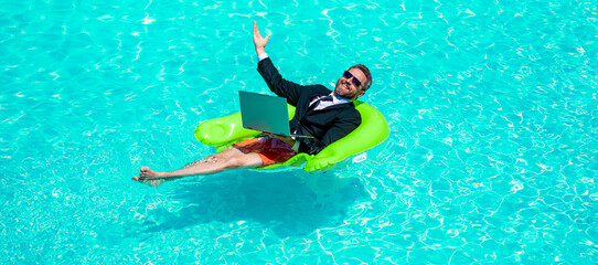 cheerful business man trading online. business man trading online in swimming pool.
