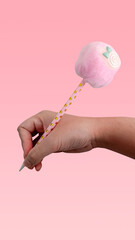 Child's hand with different stationery on isolated pink background