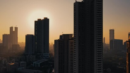 silhouette aerial View of Modern City high-rise skyscraper buildings in Mumbai City, beautiful yellow evening shot. 4k, Drone flying above the Indian city.