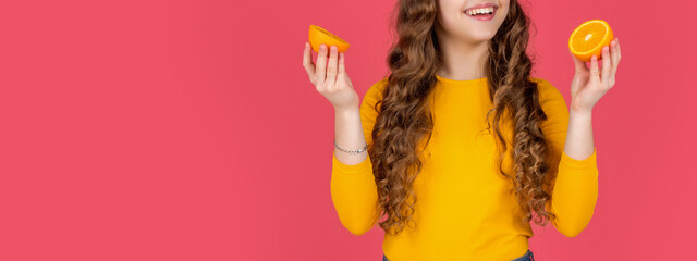 happy teen girl hold orange fruit on pink background with cpy space