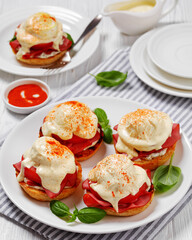 Eggs Benedict on white plate, top view