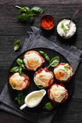 Eggs Benedict on black plate, top view