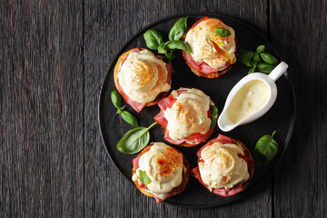 Eggs Benedict on black plate, top view