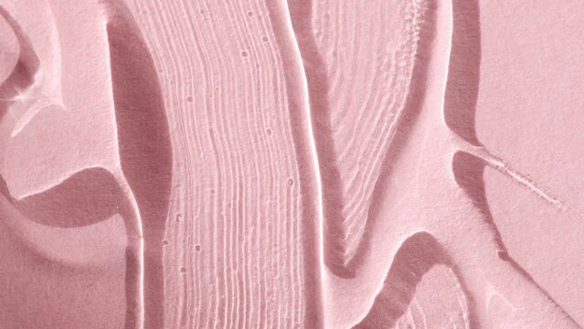 Liquid serum, transparent care product on a pink background, top view. Beauty texture macro.