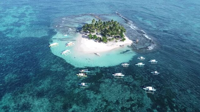 Aerial, Tour Boats anchored at the reef of Guyam Island in Siargao - Philippines.
circling around tropical lush islet
