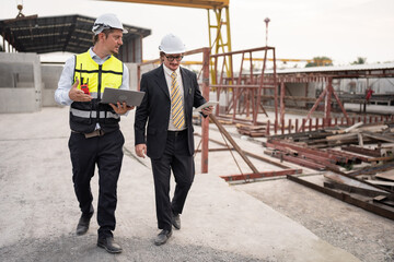 Fototapeta premium Portrait two caucasian engineer man working with notebook computer at precast site work 