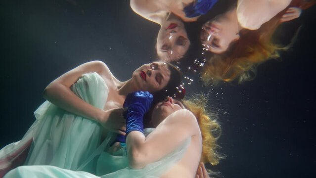 homosexual couple of two women floating underwater and kissing, lgbt community and free love