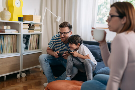Father and son compete in a video game.
