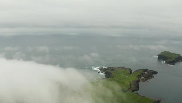Aerial view of Drangarnir cliff and Tindholmur islands in foggy weather. Faroe