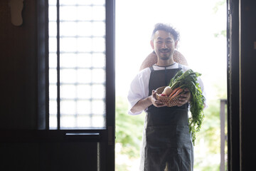 古民家に採れたて野菜を持ってくる農家の人　シルエット　カメラ目線