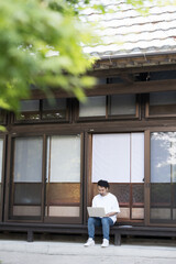 People sitting at the edge of the countryside working remotely. Wide angle for images such as workcation.