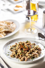 Spelt or rice creamy risotto with mushrooms and greens on a plate