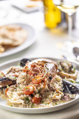 Detail of a seafood risotto made the Italian way and served on a shallow plate