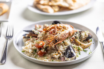Risotto con frutti di mare served on a plate with nice decoration and table setting