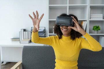 Stylish cheerful african american woman in vr headset spread arms and smiling while dancing and raising fingers in cyberspace. Metaverse vr future girl concept.