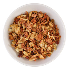 Overhead view of dried jasmine blossoms (Jasminum officinale) in a white bowl, isolated on background