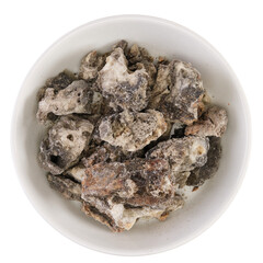 Overhead view of saumerio, a black copal tree resin from Peru, in a white bowl, isolated on background