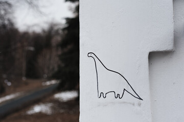 graffity of a dinosaur on a white wall