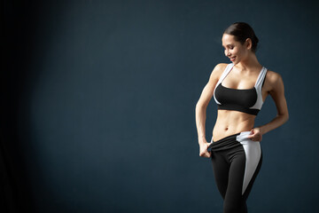 Fototapeta na wymiar Beautiful young woman, dressed in sports uniform, posing in the studio. Healthy lifestyle