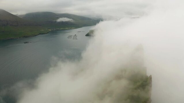 Aerial view of Drangarnir cliff and Tindholmur islands in foggy weather. Faroe