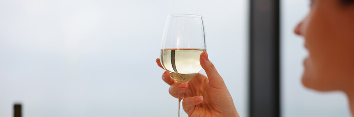 Woman drinking white wine from glass closeup. Anniversary celebration concept