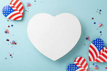 Wishing you a joyful Fourth of July! Top view of symbolic decorations: hearts adorned with the American flag pattern, confetti on a pastel blue background with an empty heart for text or advertising