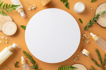 Organic cosmetics concept. Top view photo of empty circle with eucalyptus and fern branches, gypsophila, cosmetic containers and wooden stands on brown isolated background with copyspace