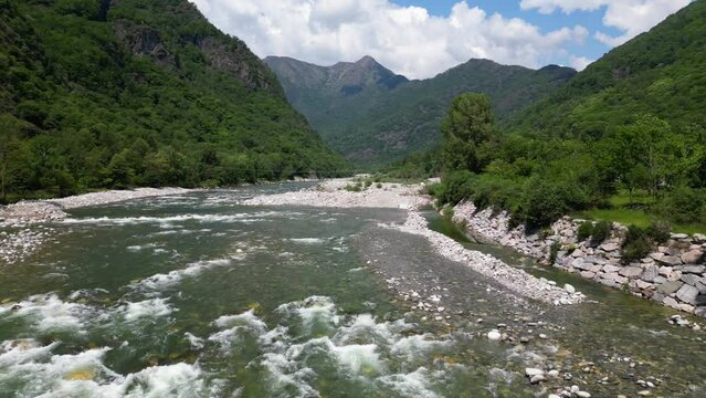 Drone flight over a wooden Tibetan suspended bridge that joins the river banks - view from the drone in Alagna Val Sesia Piedmont Alps mountains - travel concept journey in adventure natural trip 