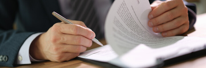 Businessman leafing through paper documents contract for signing in office closeup. Legal terms of...