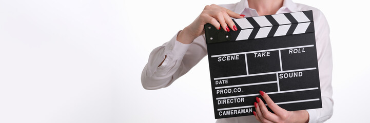 Woman assistant director banging clapper while filming closeup. Film production and cinema concept