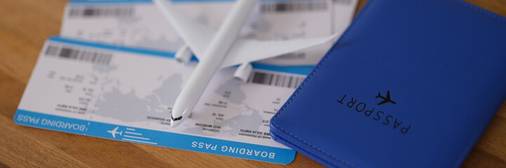 Toy plane lying on tickets near passport closeup. Airplane travel concept