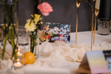 Naklejka na ściany i meble Luxury elegant table setting dinner in a restaurant. Selective focus on glasses. Preparation before the banquet table for a birthday. Wedding reception. Decor of flowers, greenery and candles. Closeup