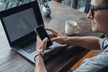 Handsome man call in smartphone, happy face, outdoor hipster portrait on the cafe, smile happy face, listen music on headphones, text, messenger, hipster, player,photo concept, laptop, coffee cup