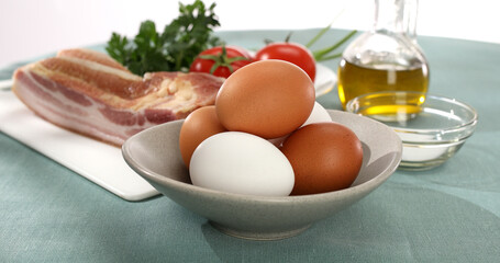 fresh eggs, bacon, vegetables and oil. ingredients for making scrambled eggs. products for breakfast. recipe for frying eggs. farm chicken eggs. natural food