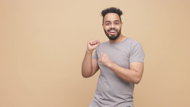 Young handsome man male feeling happy, dancing around and having fun, pointing in camera with a big smile