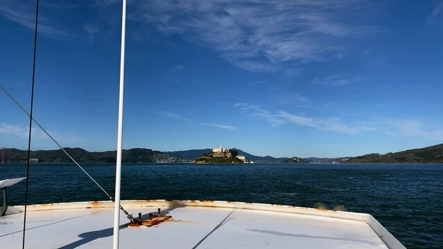 Panoramic shot of Alcatraz Prison and the Golden Gate Bridge from the front of a boat in the San Francisco Bay, United States.