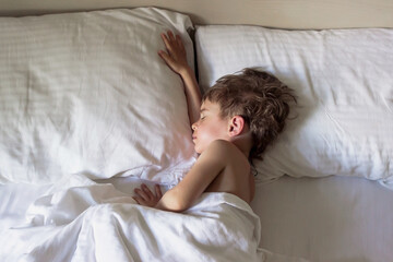 Defocused adorable little toddler boy sleeping in white bed. Child has a rest or a nap. Comfort concept. Soft focus