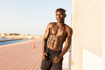 Obraz premium Fitness training outdoors. Handsome African man resting after training outside..