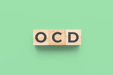 OCD (Obsessive-Compulsive Disorder) wooden cubes on green background