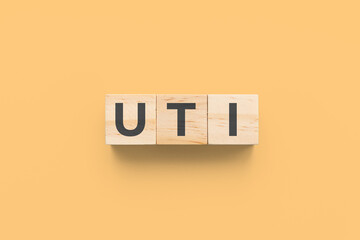 UTI (Urinary Tract Infections) wooden cubes on orange background