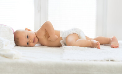 Fototapeta na wymiar Happy baby lying on bed enjoy in clen and soft new diaper