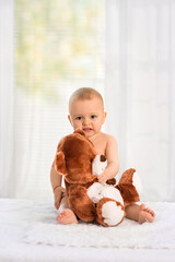 Nice baby with favorite soft toy, changing diapers