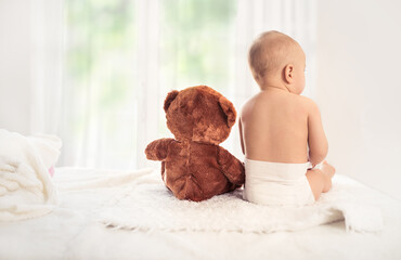 Baby in nappy with soft toy