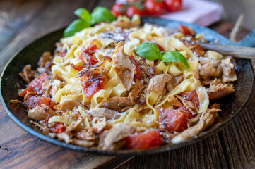 Pasta with chicken meat, tomatoes, red onions, herbs and parmesan cheese